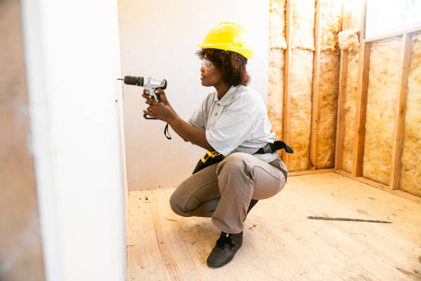 Woman Installing  drywall in unfinished wooden house